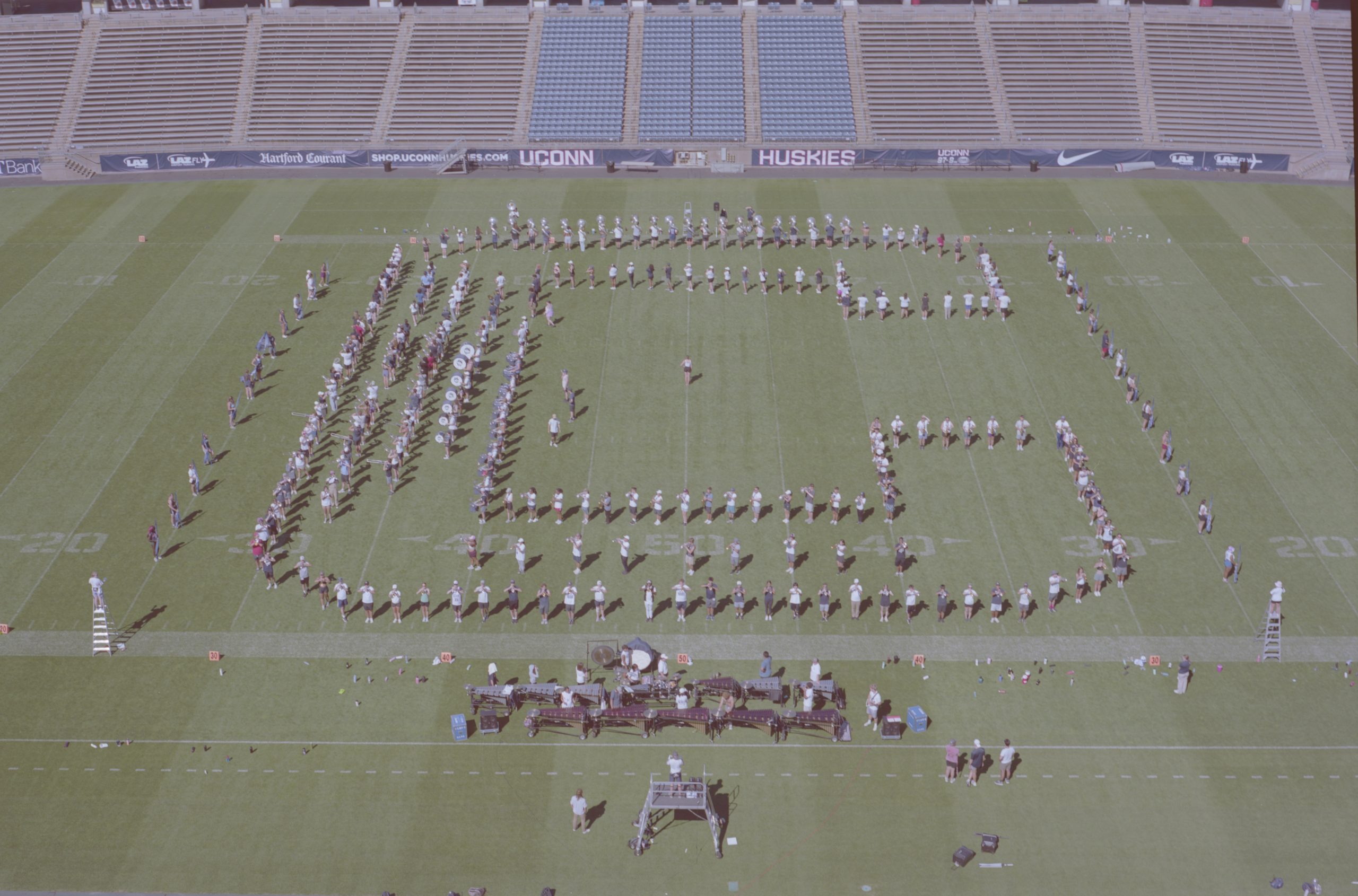 UConn Marching Band members in drill formation on the football field